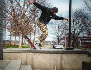 man in black jacket and brown pants jumping on skateboard